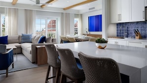 A modern kitchen with white cabinets, a blue backsplash, and a central island. - Shore House at The Del, LXR Hotels & Resorts (Coronado)