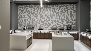 A modern kitchen with a hexagonal tile backsplash, built-in appliances, and a central island. - Home2 Suites by Hilton St. Louis Downtown (St. Louis)