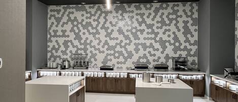 A modern kitchen with a hexagonal tile backsplash, built-in appliances, and a central island.