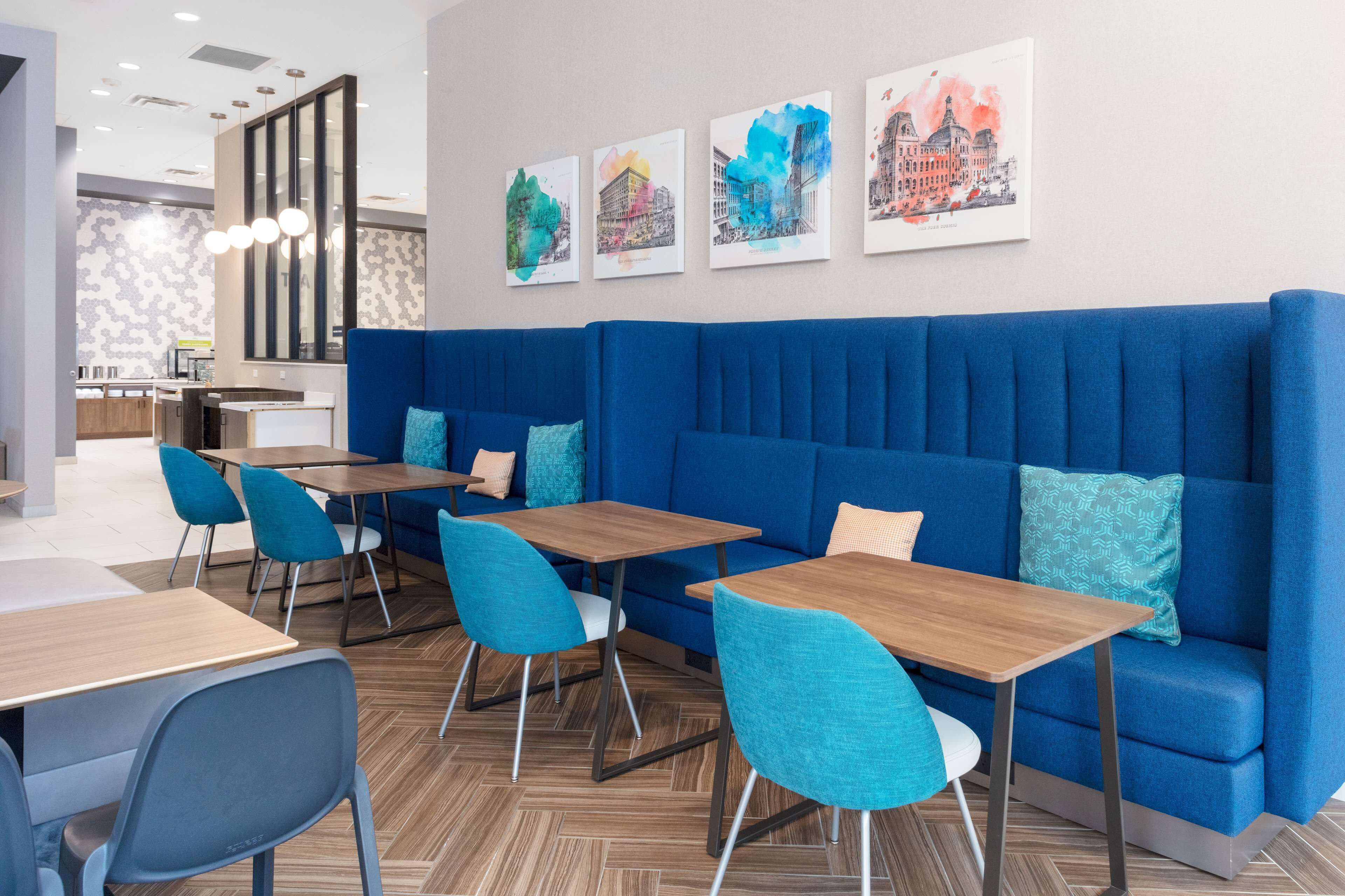 Un intérieur moderne avec un canapé bleu, des tables en bois et des chaises de couleur turquoise.