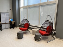 Un espacio de oficina moderno con dos sillones colgantes, un escritorio y un armario.