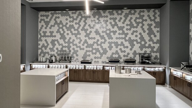 Una cucina moderna con zoccolo in piastrelle esagonali, elettrodomestici integrati e un'isola centrale.