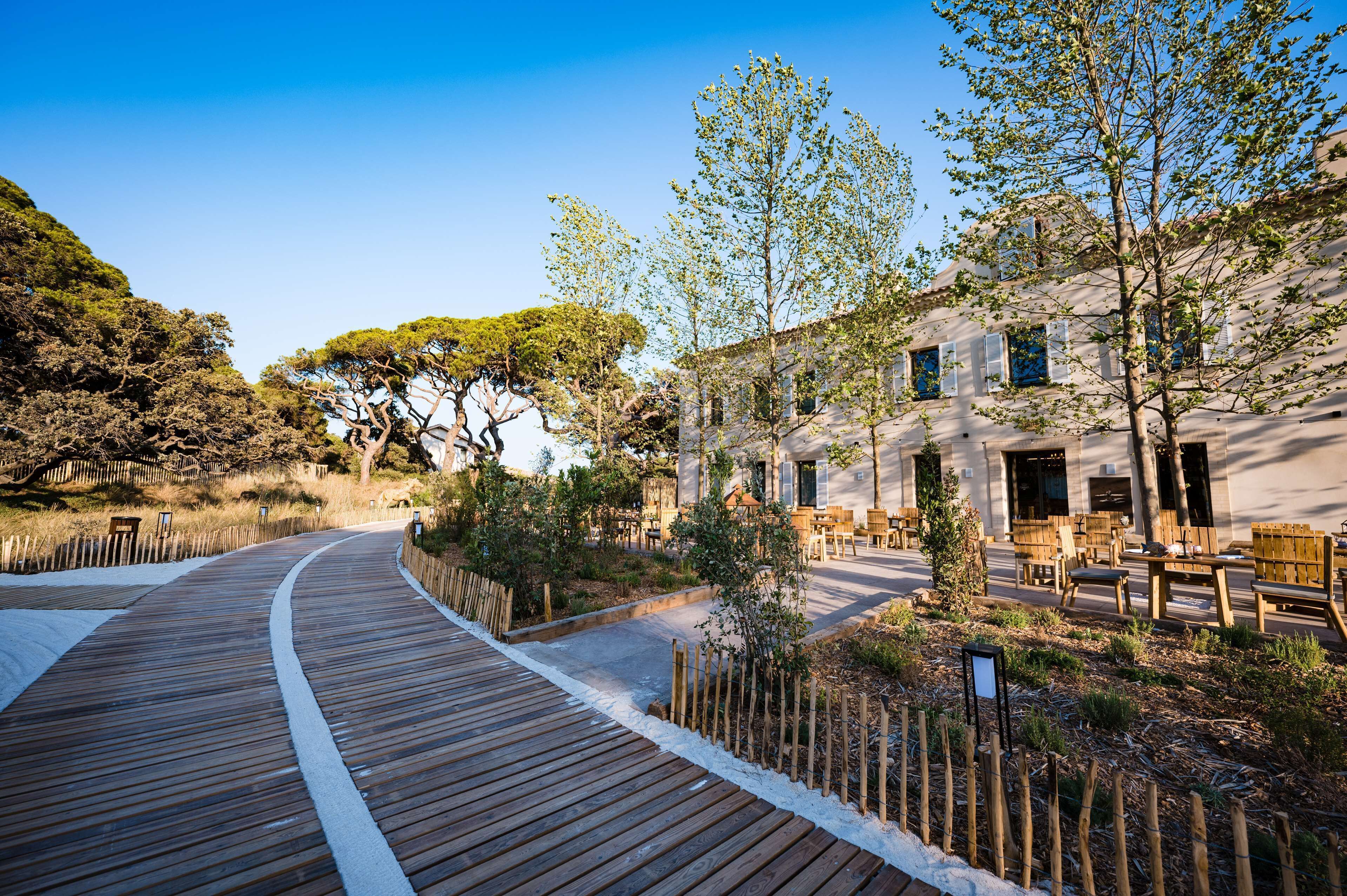 Une promenade en bois mène à un bâtiment doté d’une terrasse.