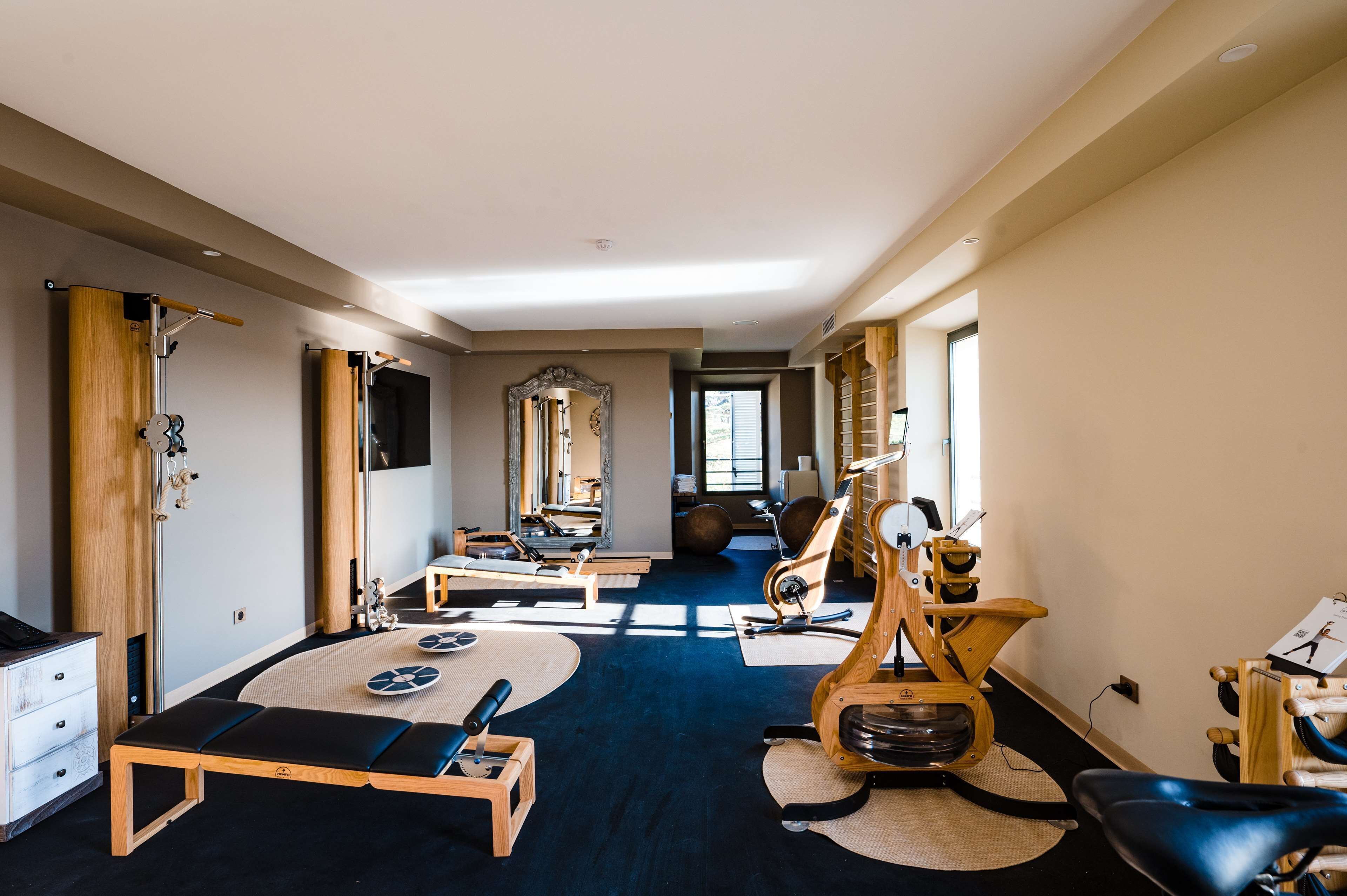 A spacious room with exercise equipment, a large mirror, and a view of the outdoors.