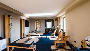A spacious room with exercise equipment, a large mirror, and a view of the outdoors.
