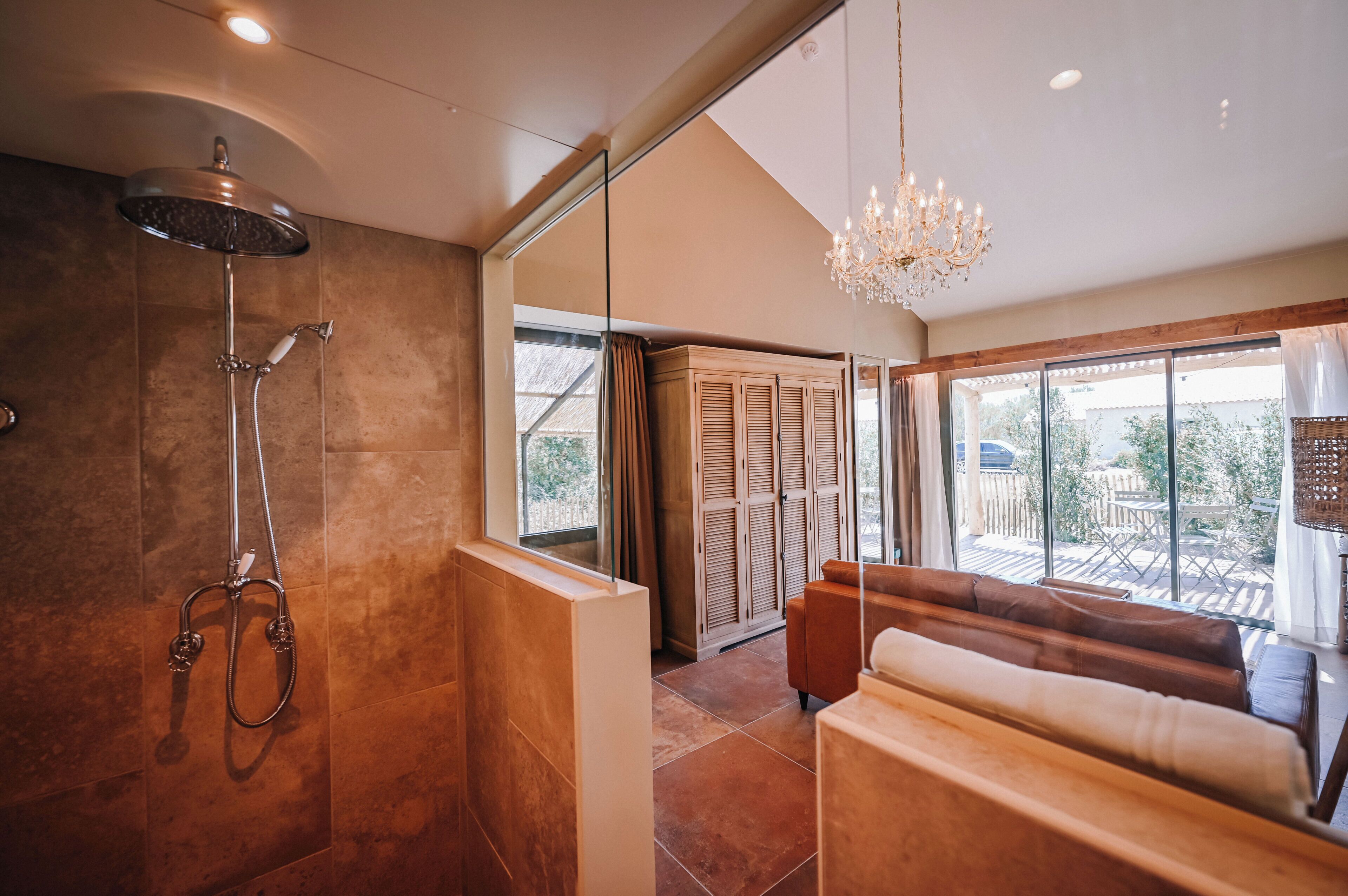 Un baño moderno con ducha, un banco y un ventanal con vistas.