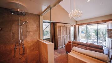 Une salle de bain moderne avec une douche, un banc et une grande fenêtre donnant sur un beau paysage.