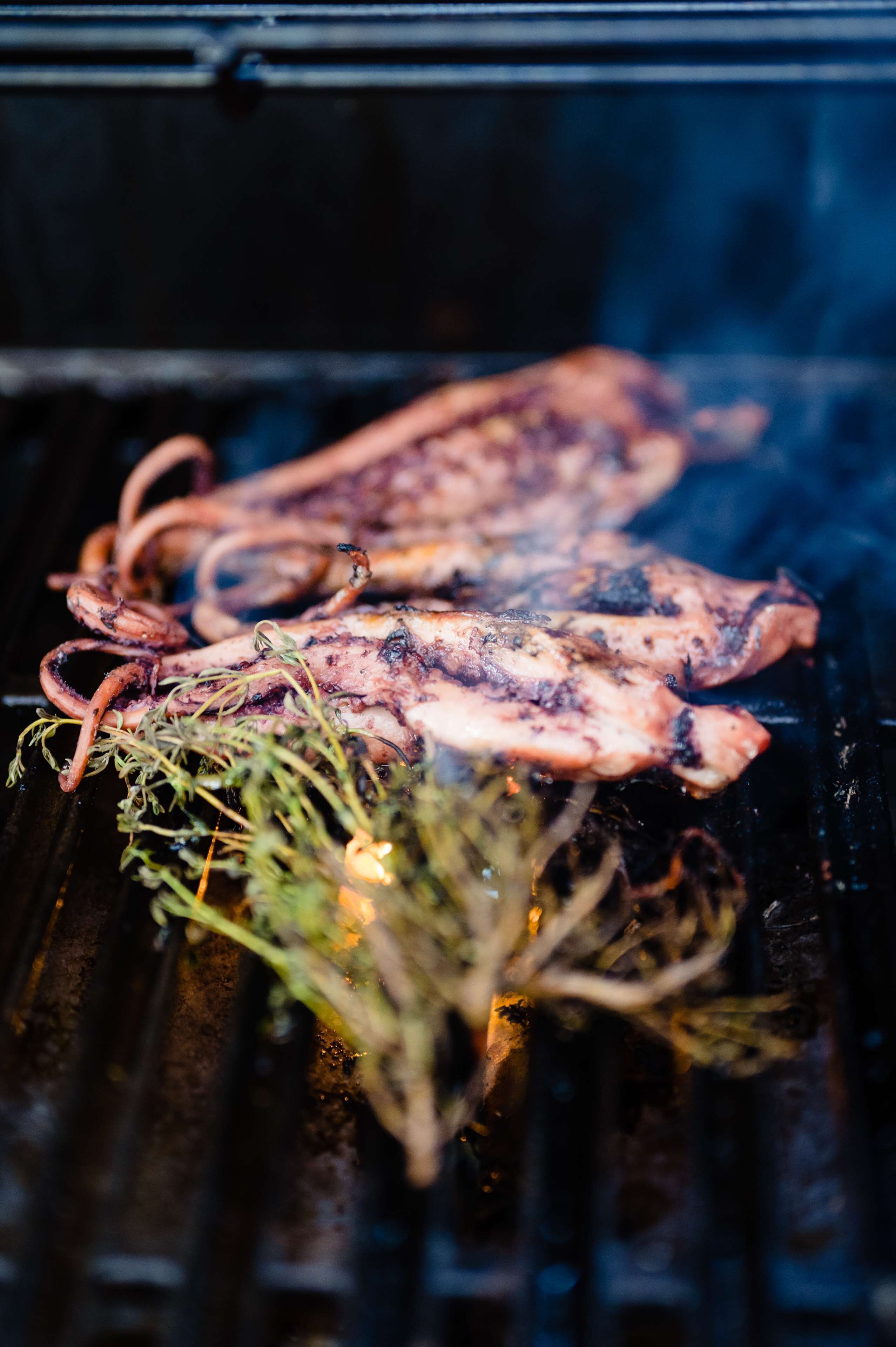 Pulpo a la parrilla con hierbas sobre una rejilla.