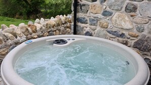 Ein Whirlpool mit Steinwand im Hintergrund.