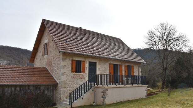 A stone house with a tiled roof, a front porch, and a staircase leading to the entrance. - Gite Le Paradis (Lacave)