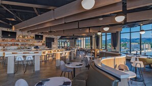 A modern bar area with a bar counter, seating, and a view of the cityscape. - Element by Marriott Colorado Springs Downtown (Colorado Springs)