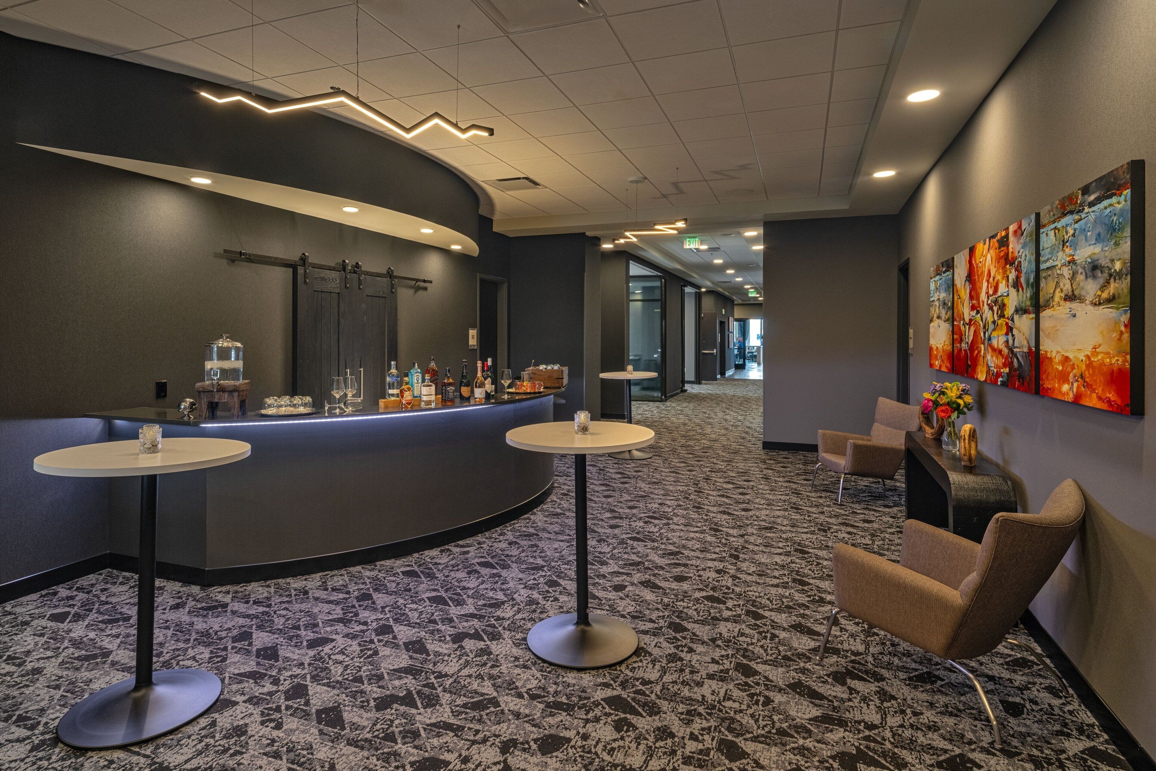 A hotel lobby with a reception desk, seating area, and artwork on the walls.