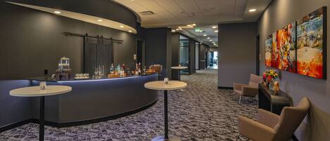 A hotel lobby with a reception desk, seating area, and artwork on the walls.