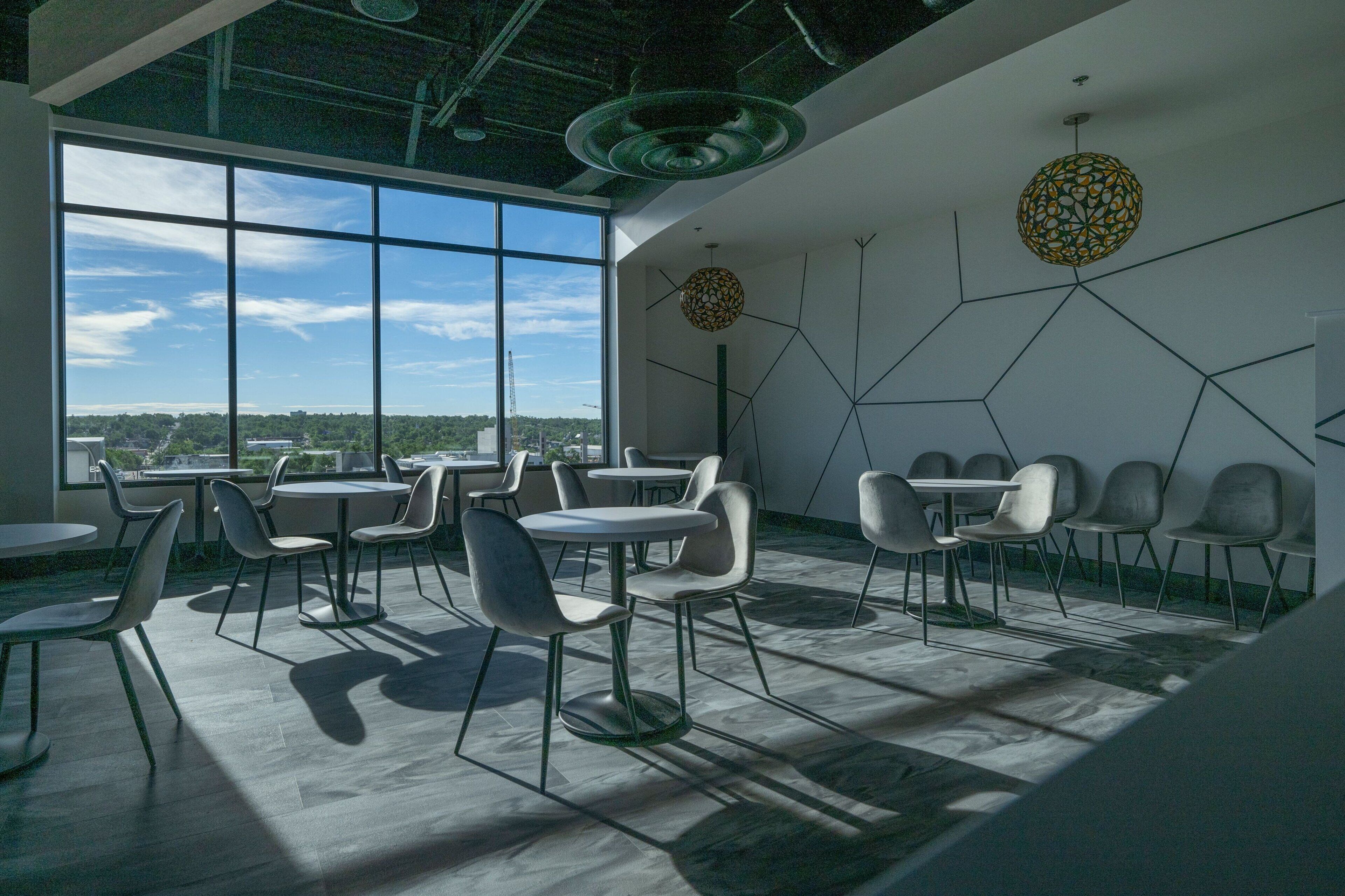 A modern interior with large windows, geometric wall art, and contemporary furniture.