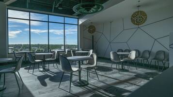 A modern interior with large windows, geometric wall art, and contemporary furniture.