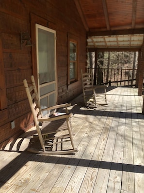 A wooden porch with rocking chairs, a door, and a window. - Cabin #4   Secluded and Quiet (Oneida)
