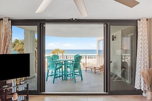 Enjoy ocean views from the balcony with a set of chairs and a table.