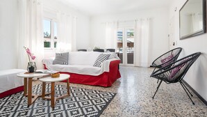 Une chambre d’hôtel avec un lit, une petite table, deux chaises, un miroir et une vue sur l’extérieur.