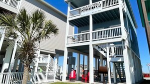 Un edificio di due piani con un balcone al piano superiore, con l'insegna 'Matagorda Outfitters River House Rentals'.