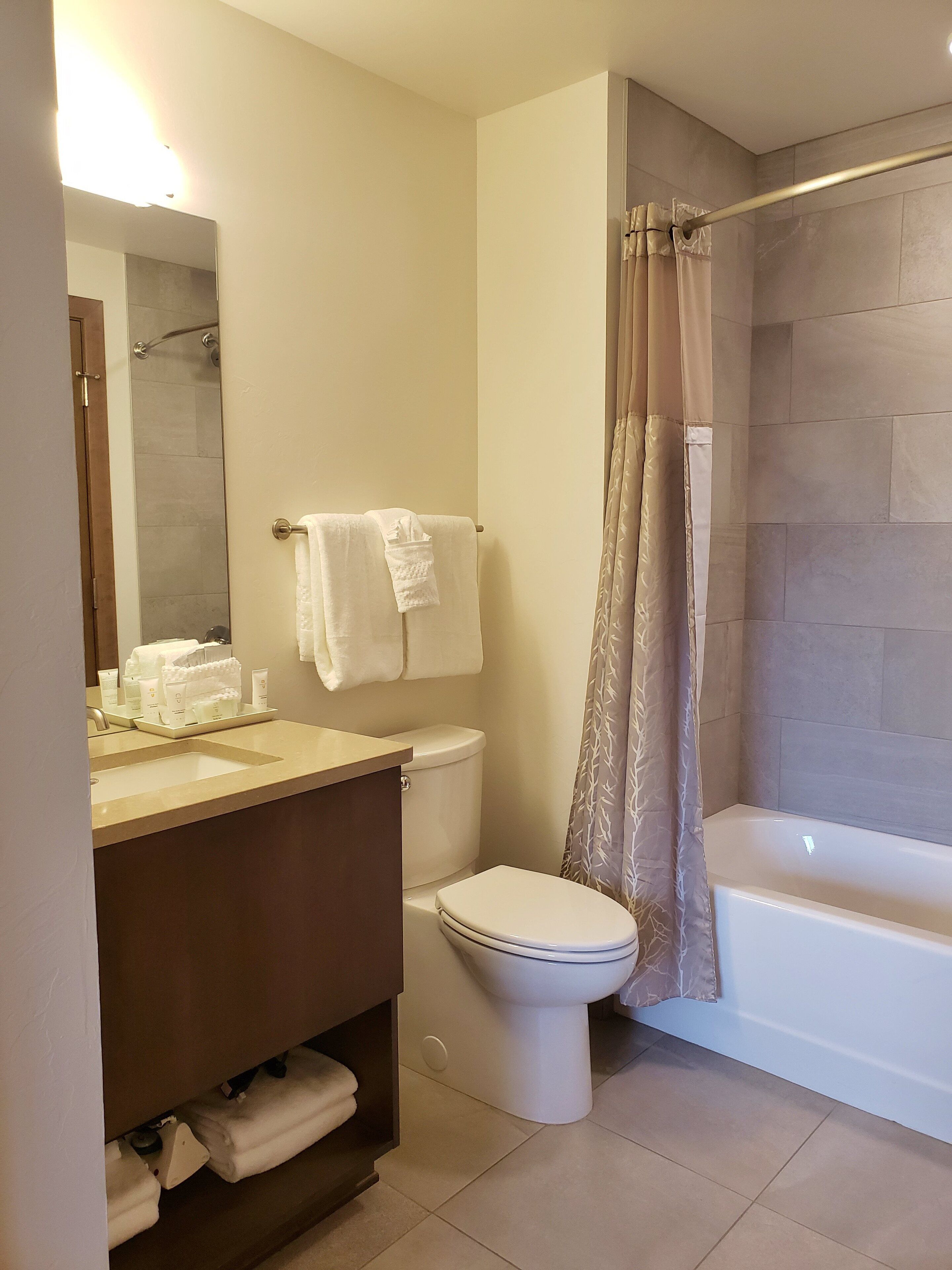 Een moderne badkamer met een wastafel, toilet en bad.