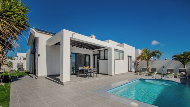A modern house with a swimming pool, a patio with chairs, and a table. - VILLA ORCADES CLOSE TO TOWN CENTER POOL & A/C (Playa Blanca)