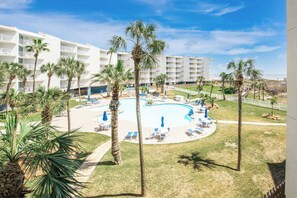 Et resort med en pool omgivet af palmer og liggestole.