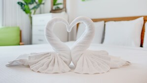 A bed with a heart-shaped towel arrangement.