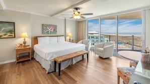 Une chambre d’hôtel avec un grand lit, un balcon avec vue, un bureau et une chaise.