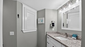 A bathroom with a sink, mirror, and towel rack.