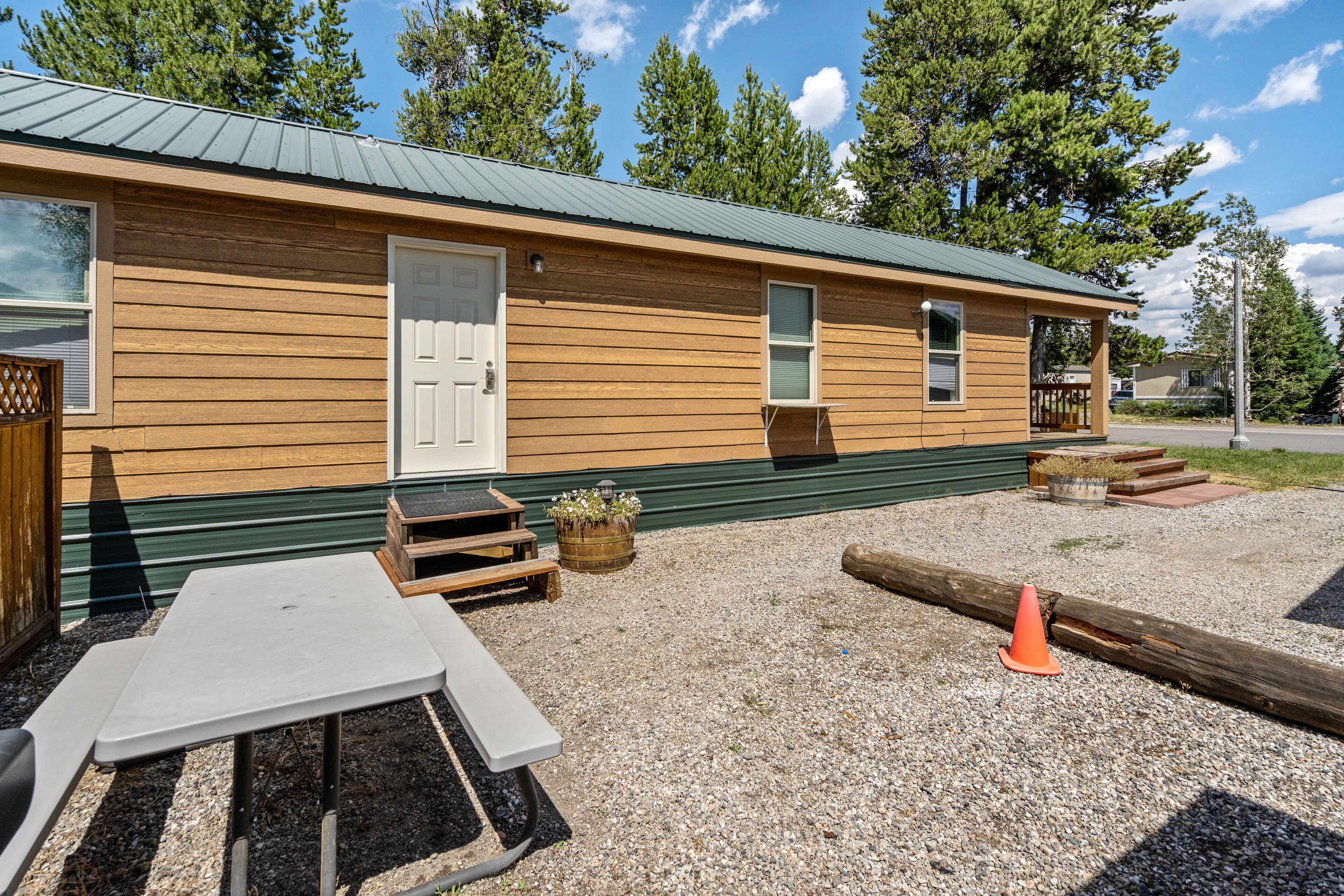 A wooden cabin with a door, windows, and a small porch area.