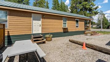 A wooden cabin with a door, windows, and a small porch area.