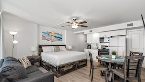 Ein modernes Schlafzimmer mit einem großen Bett, einem Esstisch und einer Küchenzeile.