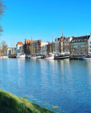 En kanal med fortøjede både, omgivet af historiske bygninger med forskellig arkitektur.