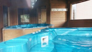 A hot tub with a wooden deck and a window. - Cozy Mountain Condo w/Outdoor Heated Pool Access (Fraser)