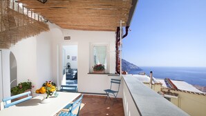 An outdoor patio with a table, chairs, and a view of the sea. - Estate4home - Villa Settemari (Positano)
