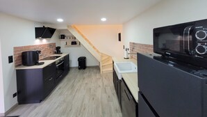 A compact kitchen with a microwave, coffee maker, and a wooden staircase leading to another level. - House near nogent sur Seine (Crancey)
