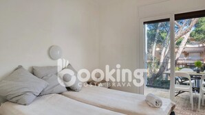 A hotel room with two beds, a large window, and a view of the outdoor area. - APARTMENT FOR 6 PEOPLE WITH PARKING 2 MINUTES FROM THE BEACH (Platja d'Aro)