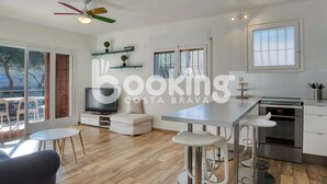 A modern kitchen with a dining area, a TV, and a ceiling fan. - APARTMENT FOR 6 PEOPLE WITH PARKING 2 MINUTES FROM THE BEACH (Platja d'Aro)
