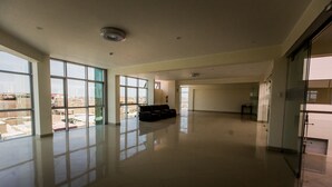 Un interior amplio y luminoso con grandes ventanales que ofrecen vistas del paisaje urbano.