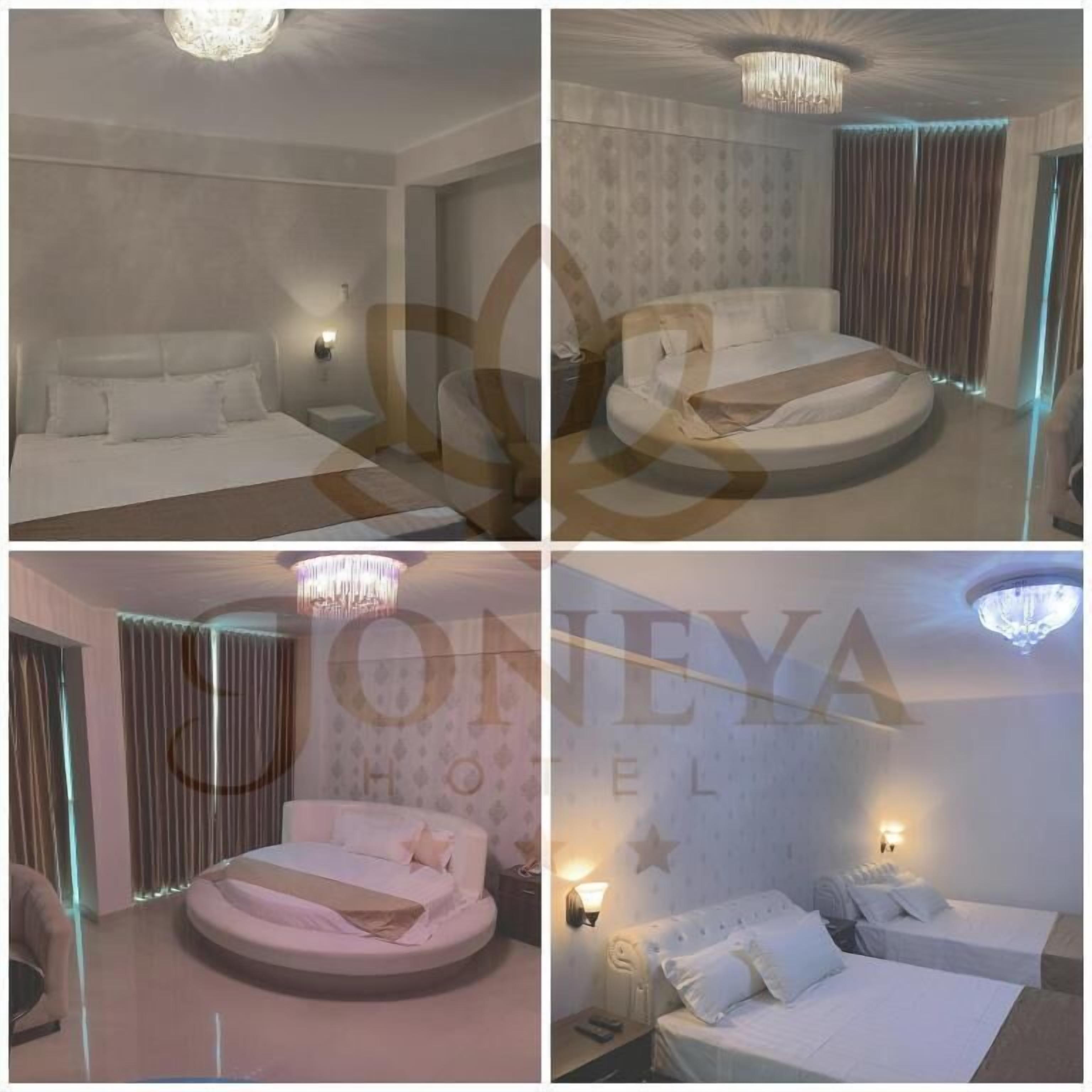 A hotel room with a bed, a round seating area, and a chandelier.