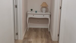 A hallway with a white console table, a lamp, and a small plant. - 2 bedroom apartment Sao Giao 10A in Tomar (Tomar)