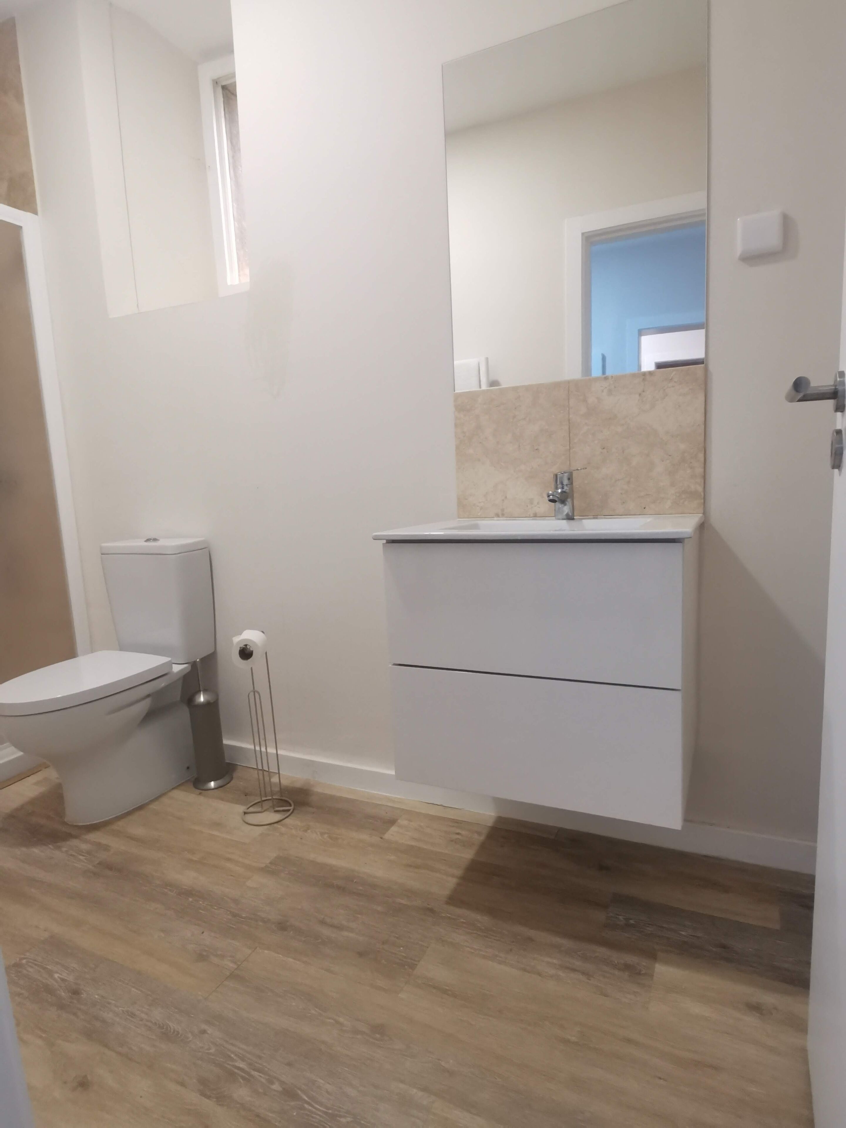 Ein Badezimmer mit Toilette, Waschbecken und Spiegel.