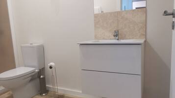Ein Badezimmer mit Toilette, Waschbecken und Spiegel.