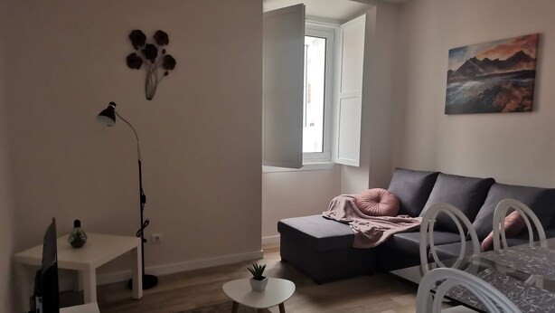A modern living room with a sofa, a small table, a TV, and a painting on the wall. - 2 bedroom apartment Sao Giao 10A in Tomar (Tomar)