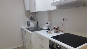 A compact kitchen with white cabinets, a built-in oven, and a coffee maker. - 2 bedroom apartment Sao Giao 10A in Tomar (Tomar)