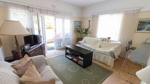 A living room with a sofa, a coffee table, a TV, and a bookshelf.