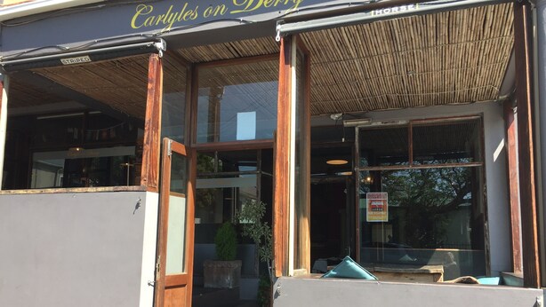 A storefront with a sign reading "Carlyles on Derby."