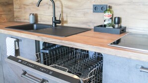 A kitchen with a wooden countertop, a black sink, and a dishwasher built into the cabinetry. - New York style, parking lot, lockable bike box with charging facility  (Koblenz)