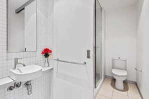 Un baño moderno con ducha, inodoro y lavamanos.