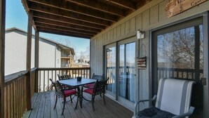 A covered deck with a table and chairs, a glass door, and a sign reading "L. Heed Cabin." - Westcreek Ranch - No Stairs! (Branson West)